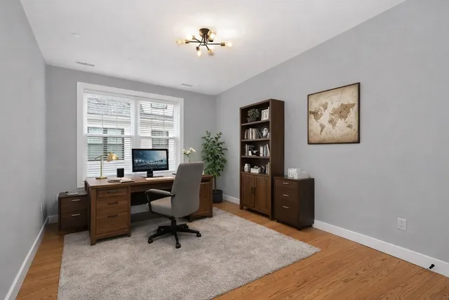 a view of a workspace with furniture and a window