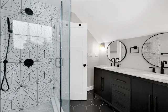 a bathroom with a double vanity sink mirror and shower