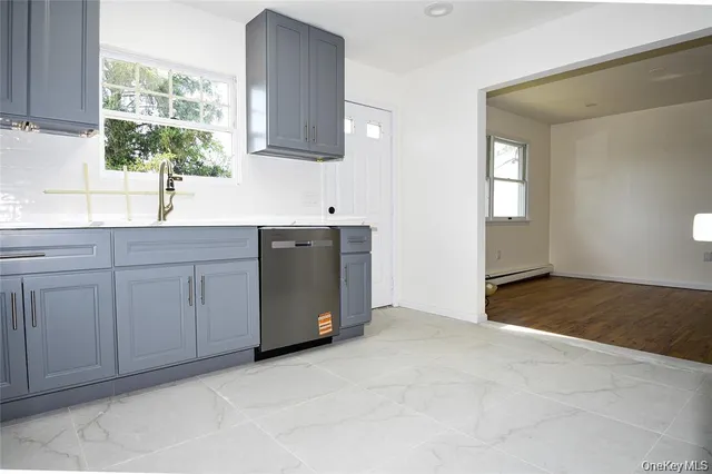 a kitchen with white cabinets a sink and a window