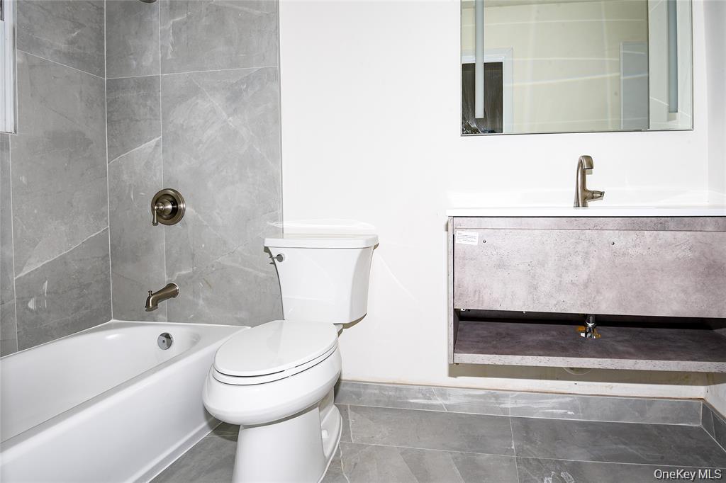 65 Bluebird Lane Plainview, NY 11803 - Photo 14 of 28 a bathroom with a toilet a sink and bathtub