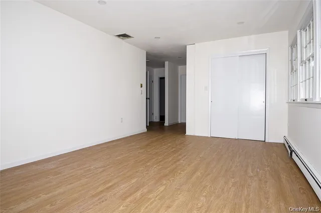 a view of an empty room with wooden floor