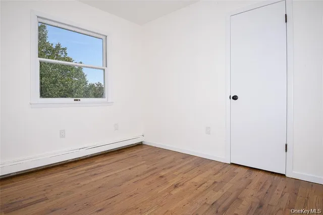 a view of a small space with wooden floor and a window