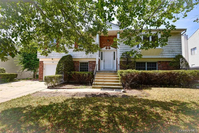 a front view of a house with a yard covered with snow