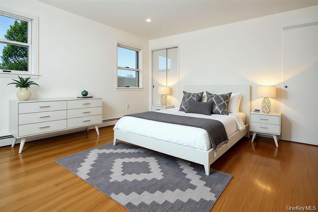 65 Bluebird Lane Plainview, NY 11803 - Photo 9 of 28 a bedroom with a bed and a potted plant