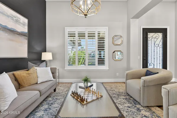 a living room with furniture a fireplace and a chandelier
