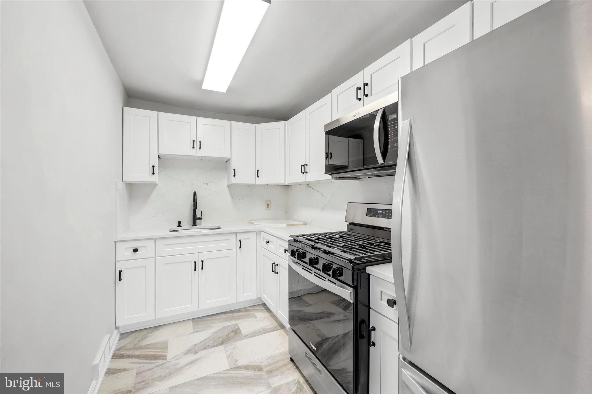 2052 Heather Road Folcroft, PA 19032 - Photo 9 of 17 a kitchen with stainless steel appliances white cabinets and a stove top oven