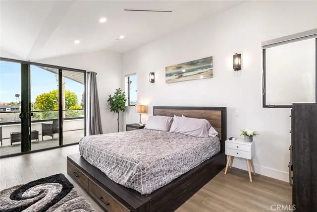 a bed sitting in a spacious bedroom next to a large window