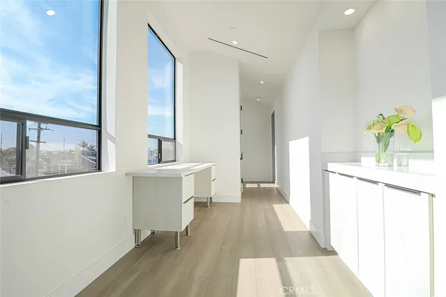 a view of a hallway with wooden floor and furniture
