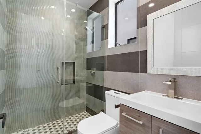 a bathroom with a sink a toilet and shower