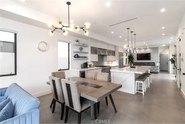 a view of a dining room with furniture a kitchen and chandelier
