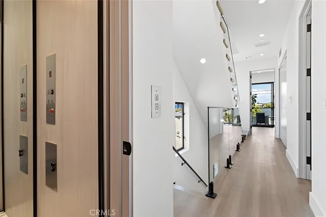 a view of a hallway with wooden floor and staircase