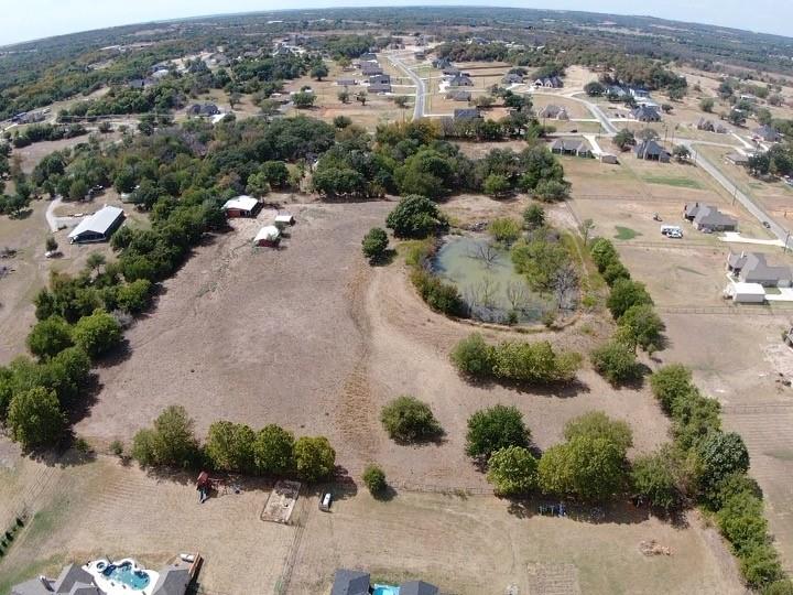 an aerial view of a house with a yard and lake view in back