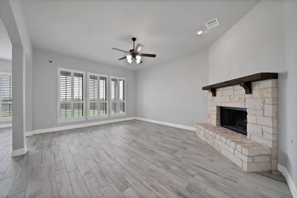 a view of an empty room with a fireplace and a window