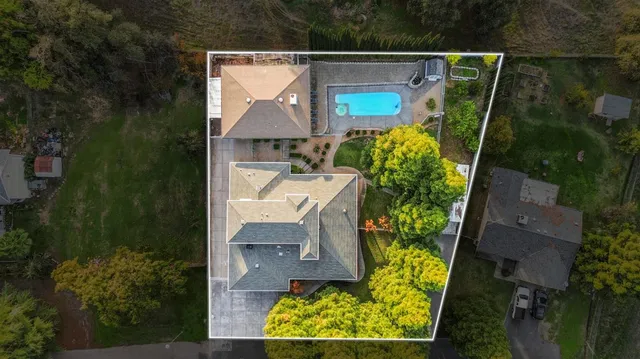 an aerial view of a house with swimming pool outdoor seating and yard