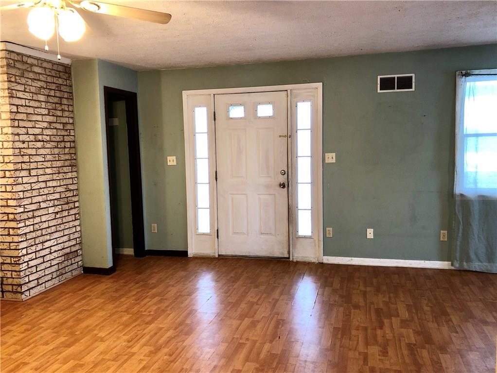 775 Beacom Drive Beaver, PA 15009 - Photo 2 of 15 View of the front door from the Living /Dining area. Exposed brick wall, coat closet, subtle tones on the walls and laminate floors.