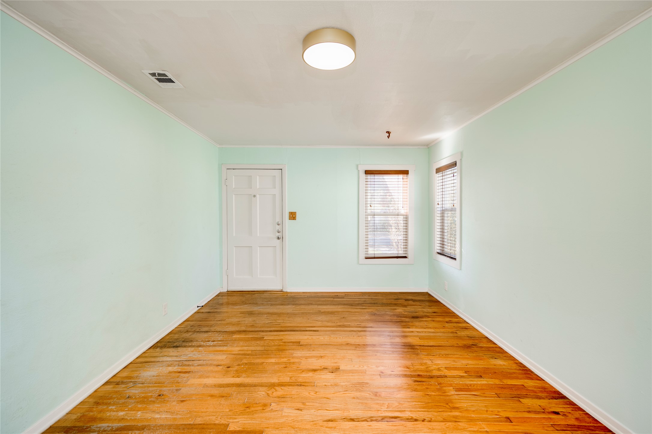 4804 Tanney Street Austin, TX 78721 - Photo 11 of 40 Hardwood floors and crisp light green walls characterize this versatile interior space, ready for personalization.