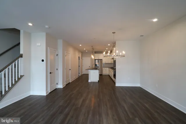 a dining room with wooden floor and chandelier