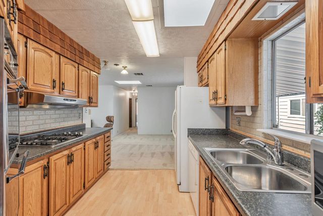 a kitchen with stainless steel appliances granite countertop a sink stove and cabinets