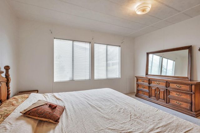 a bed sitting in a bedroom next to a window