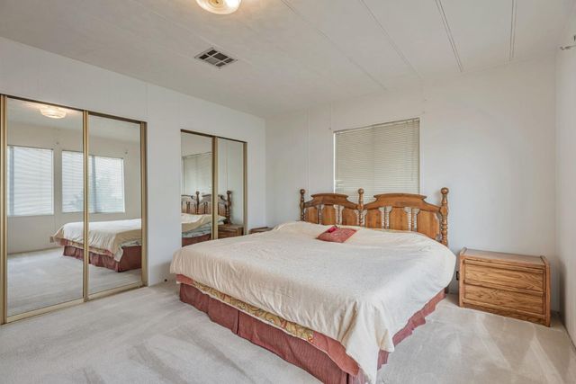 a bedroom with a bed and a view of living room