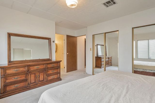 a bedroom with a bed and a large mirror