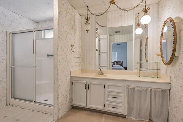 a spacious bathroom with a double vanity sink a large mirror a shower and a bathtub