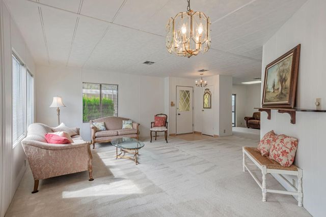 a living room with furniture and chandelier