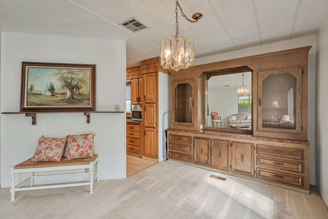 a view of a hallway with wooden floor and chandelier