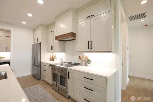 a kitchen with stainless steel appliances a sink stove and refrigerator