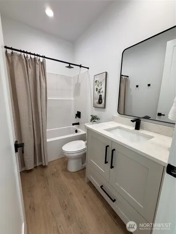 a view of a hallway with wooden floor and entryway