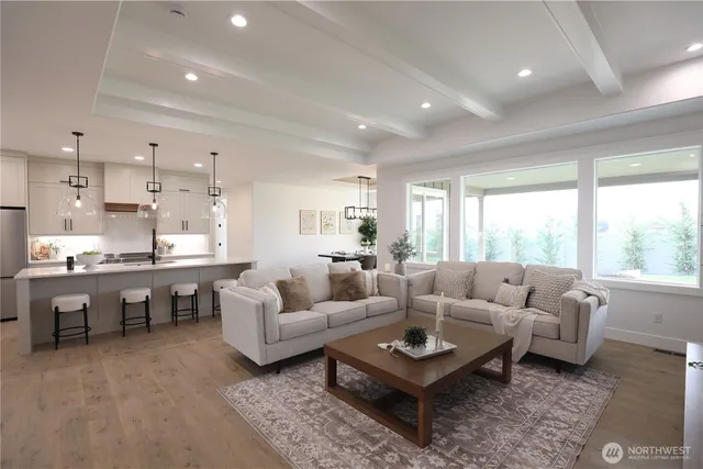 a living room with furniture kitchen view and a large window