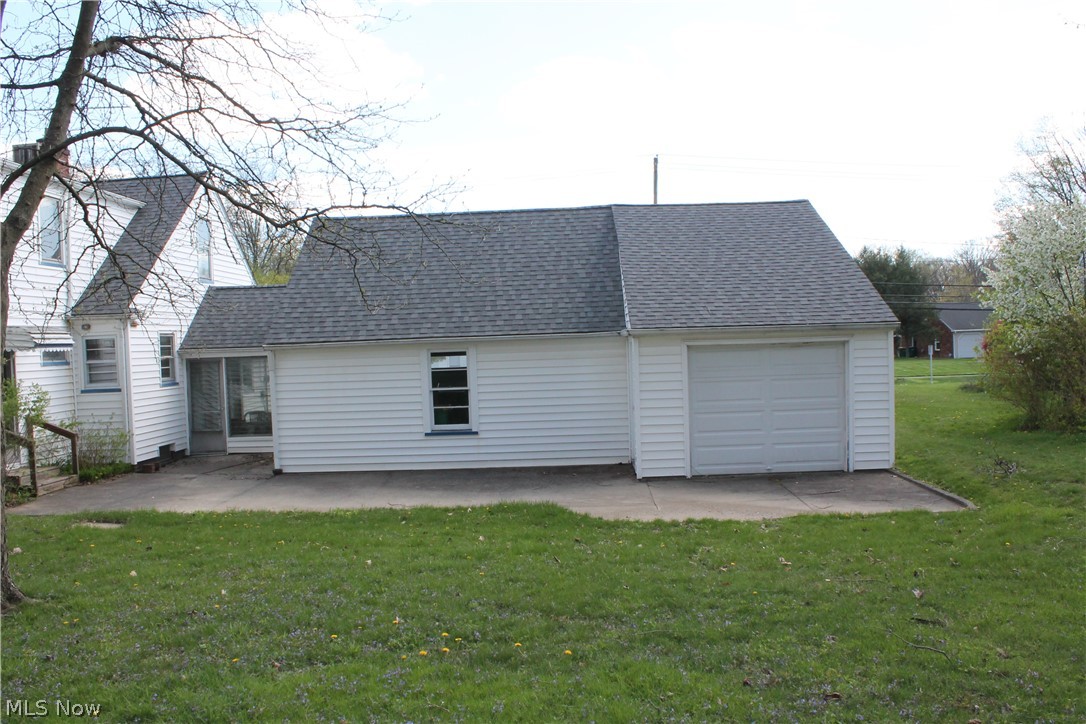 14863 Turney Road Maple Heights, OH 44137 - Photo 32 of 34 Rear view of property featuring a lawn, a garage, and a patio area