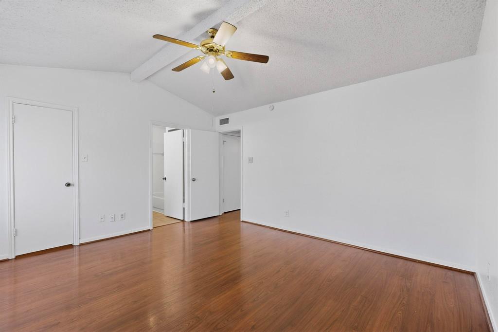 8545 Midpark Road, Unit 16 Dallas, TX 75240 - Photo 22 of 29 Unfurnished bedroom with beamed ceiling, dark wood-style flooring, a textured ceiling, ceiling fan, and ensuite bath
