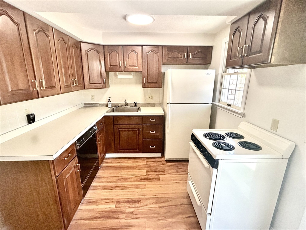 40 Corey Colonial, Unit 40 Agawam, MA 01001 - Photo 7 of 21 a kitchen with stainless steel appliances granite countertop a stove a sink dishwasher and a refrigerator with wooden cabinets