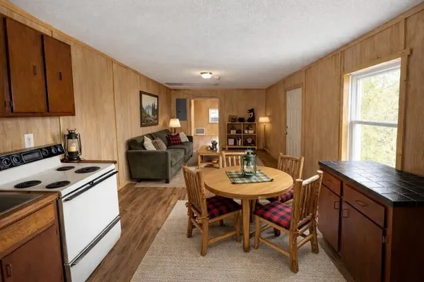 a kitchen with a dining table chairs and a refrigerator