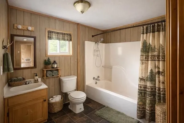 a bathroom with a granite countertop bathtub shower sink vanity and toilet