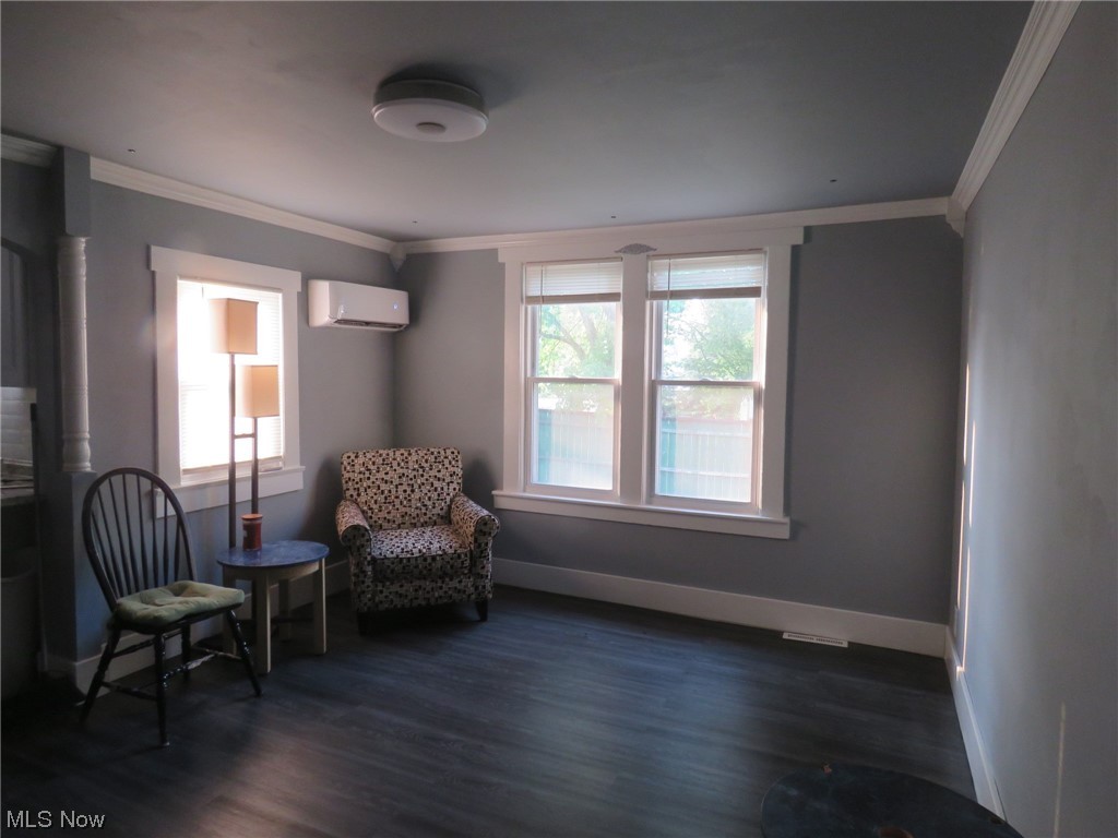 10451 Lagrange Road Elyria, OH 44035 - Photo 7 of 21 Living area with dark wood-type flooring, a wall unit AC, and crown molding
