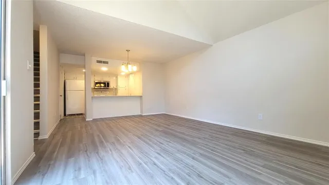 a view of a room with wooden floor and a kitchen