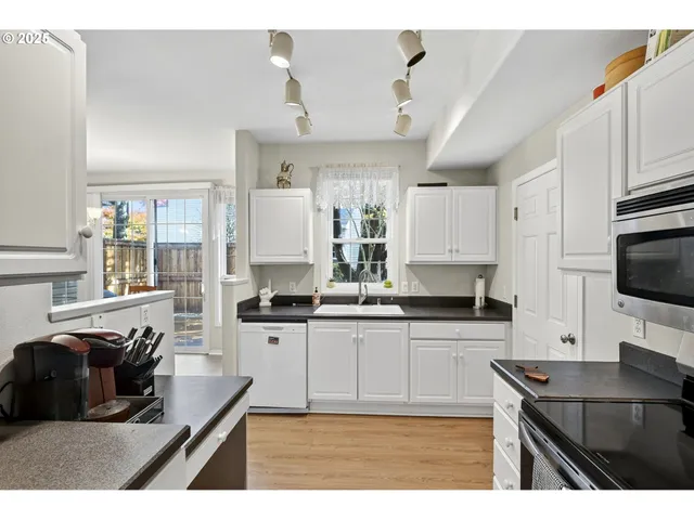 a kitchen with granite countertop a sink counter top space appliances and cabinets