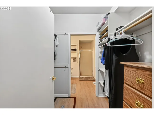 a view of walk in closet with clothes and shoes