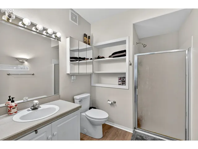 a bathroom with a sink a toilet and shower