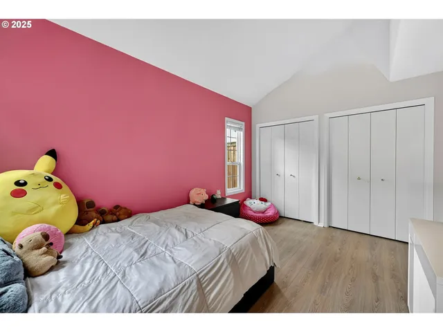 a bedroom with pink bed and wooden floor