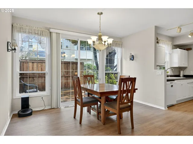 a dining room with furniture large windows and a chandelier