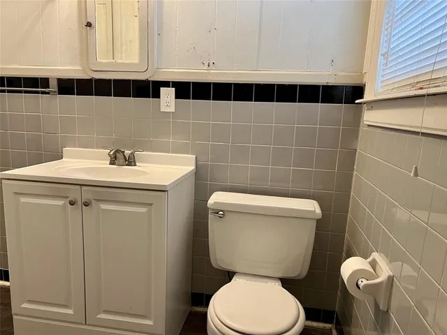 a bathroom with a toilet a sink and mirror