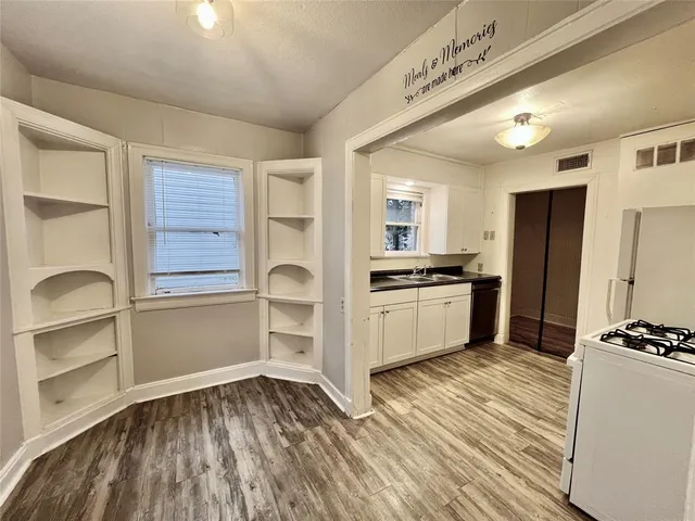 a kitchen with granite countertop a refrigerator and a stove top oven