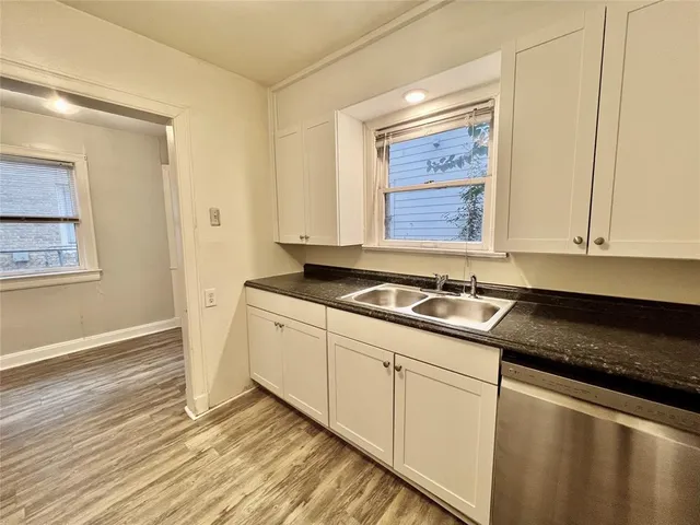 a kitchen with granite countertop white cabinets and sink