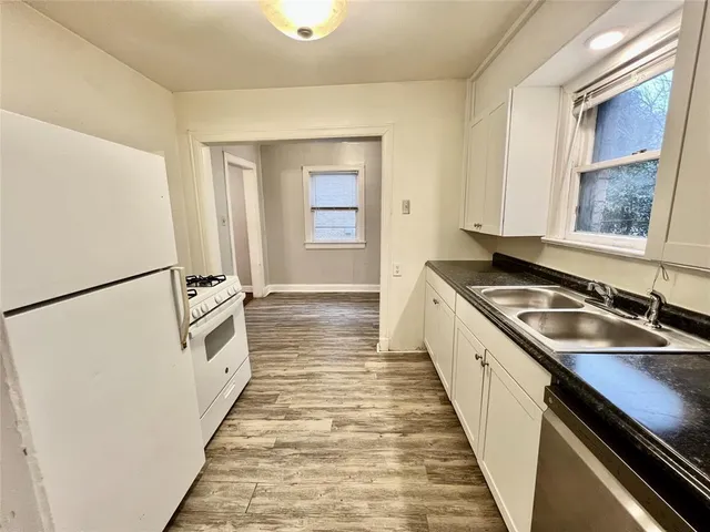 a kitchen with granite countertop a sink stove and refrigerator
