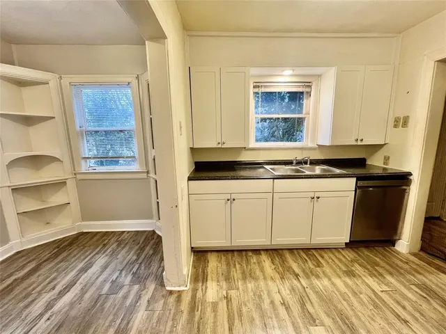 a view of a kitchen with wooden floor and electronic appliances