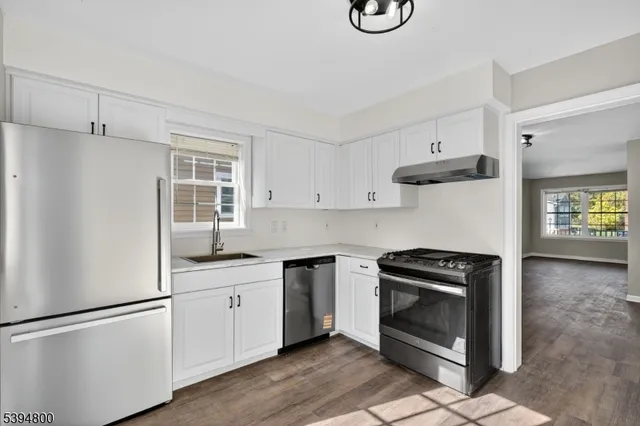 a kitchen with white cabinets and white appliances