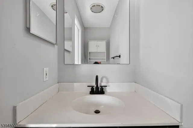 a bathroom with a sink a mirror and vanity